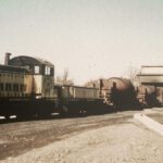 Vintage train beside industrial building