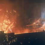 Worker in protective gear near molten metal
