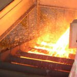 Molten metal pouring into industrial furnace